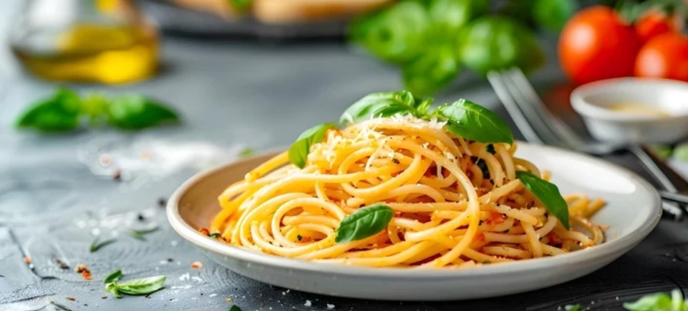 A plate of spaghetti pasta with garlic, olive oil and basil.