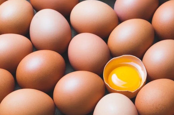 Whole raw eggs with one broken open