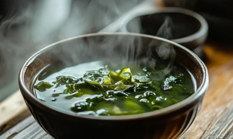 A bowl of miso soup with seaweed